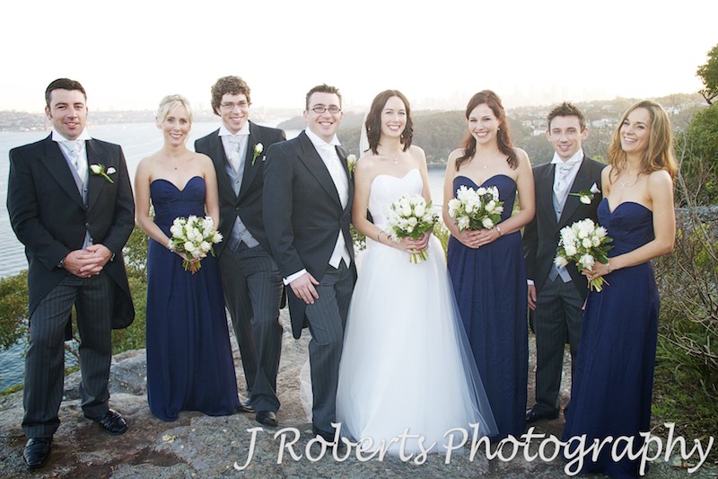 Bridal party laughing with Sydney Harbour in the background - wedding photography sydney